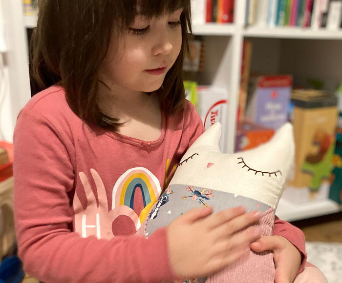 Niña abrazando un muñeco de Churricos