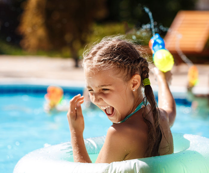 Niña jugando en una piscina | Beneficios MP | Carrasco Polo