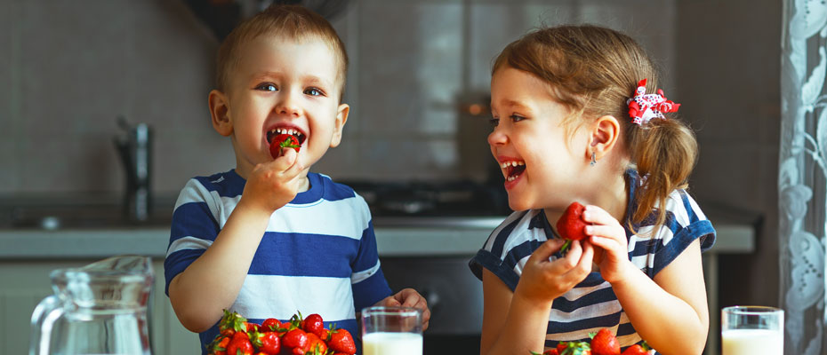 Niños comiendo frutillas con leche | Endulzantes en niños: ¿sí o no?